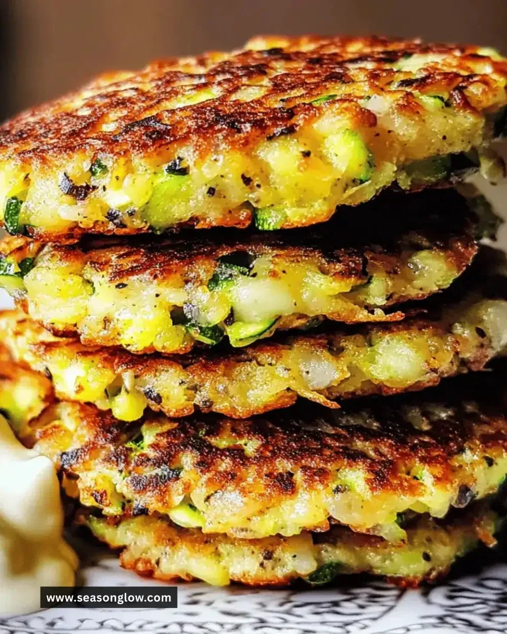Crispy zucchini fritters on a plate, garnished with herbs