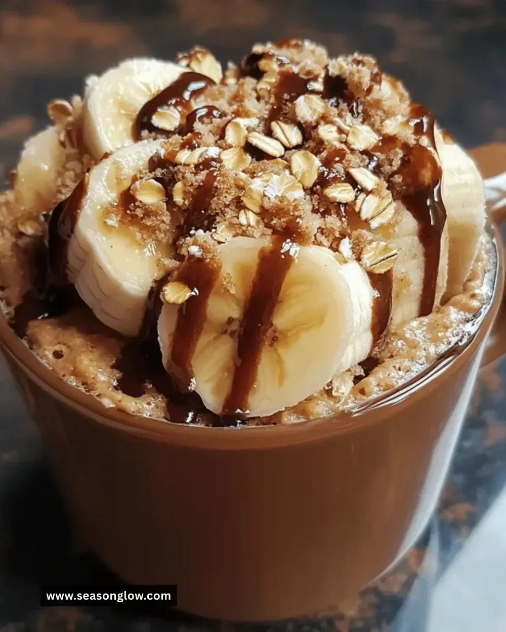 Gluten-free banana oat mug cake topped with slices of banana and oats