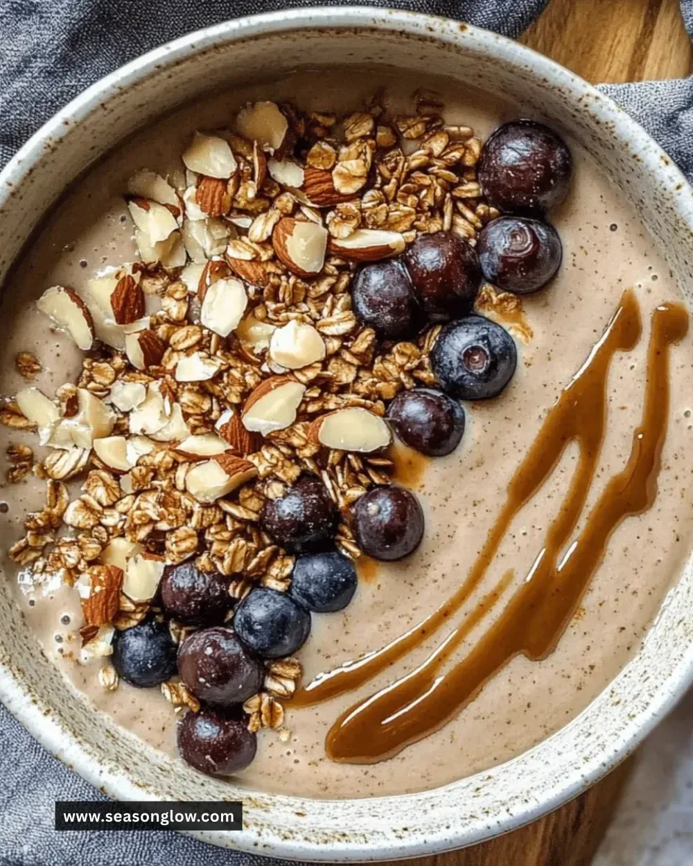 Creamy almond butter smoothie bowl topped with fresh fruit and granola
