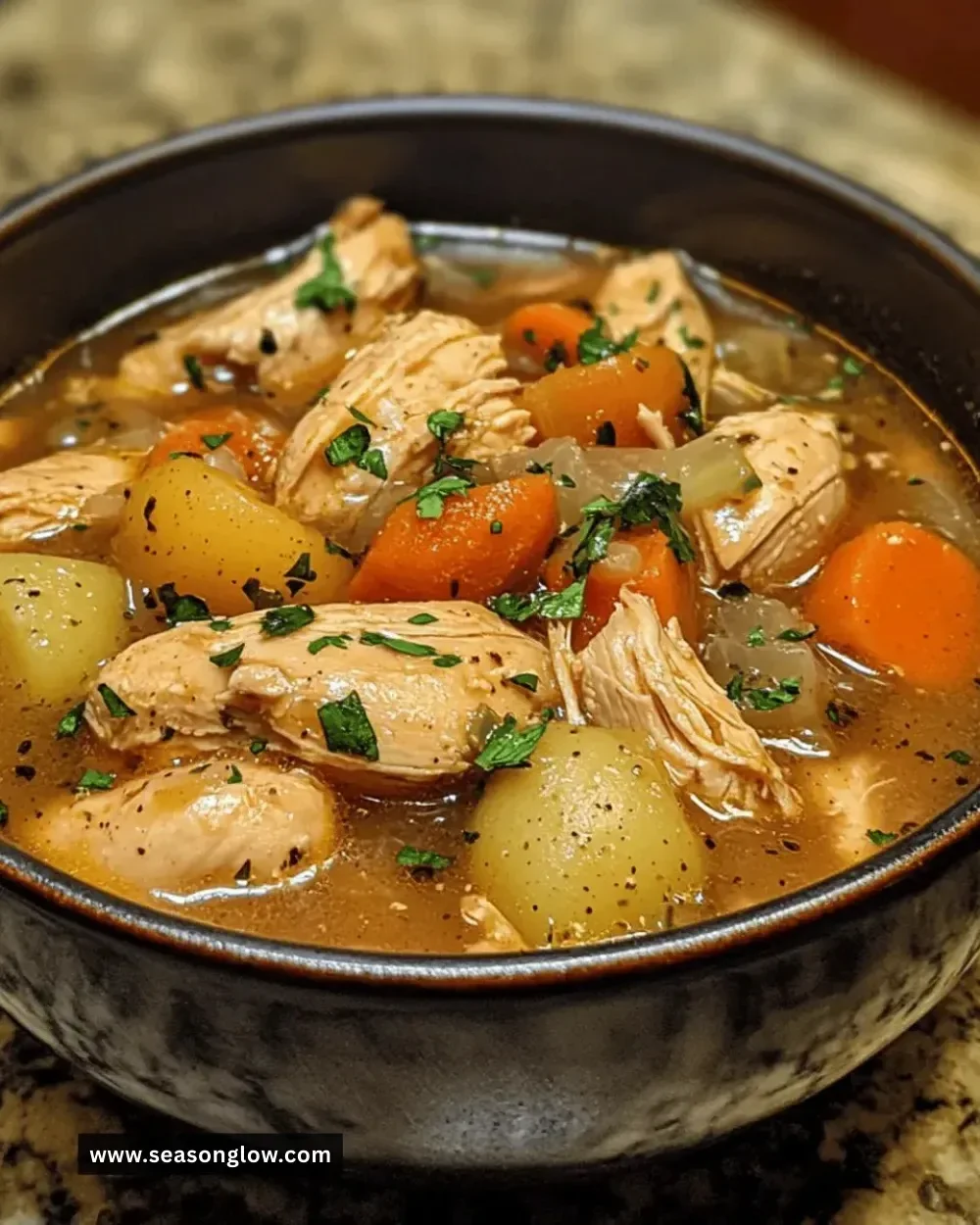 Bowl of easy crockpot chicken stew with vegetables and herbs