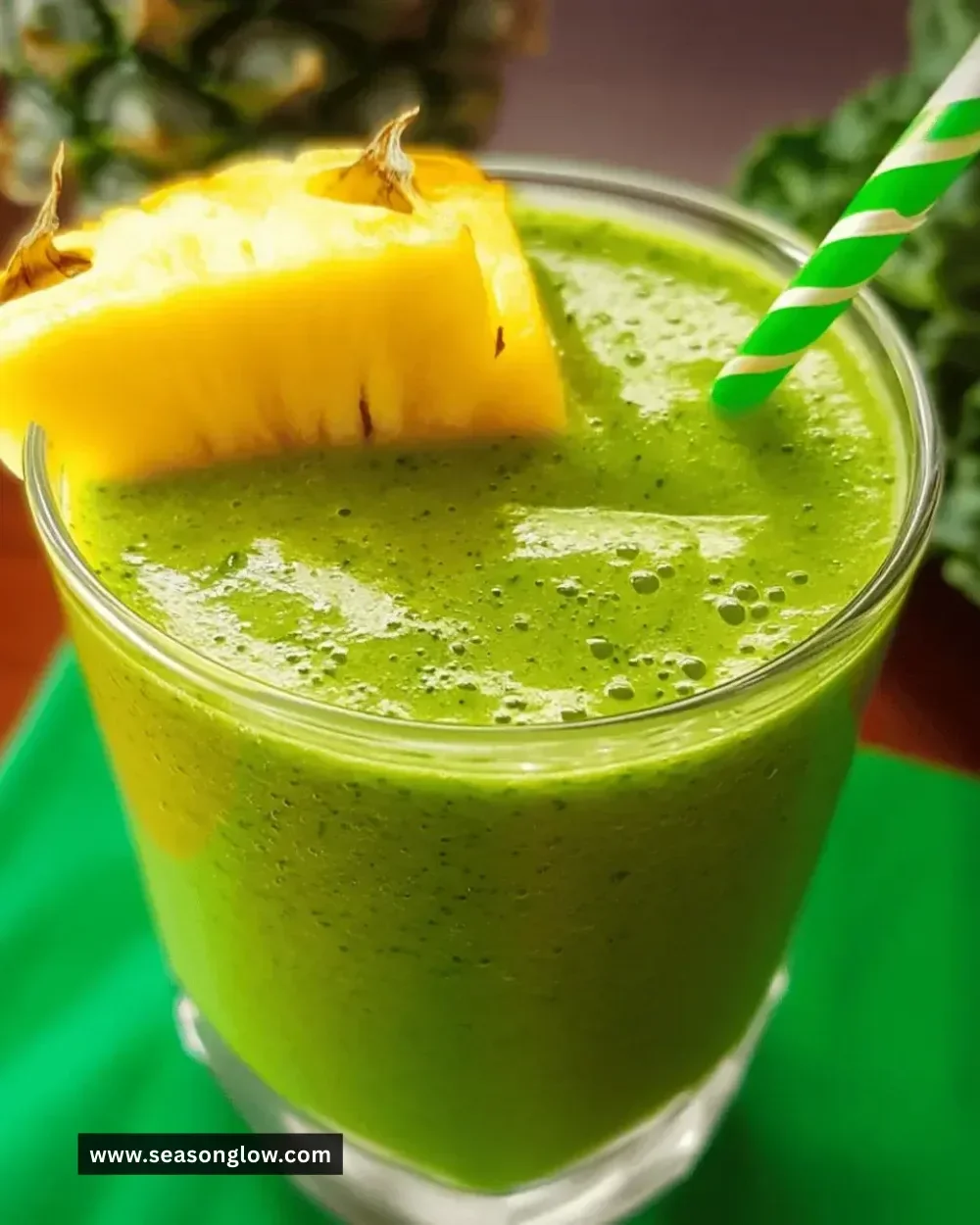 Easy pineapple kale smoothie in a glass with fresh ingredients around it