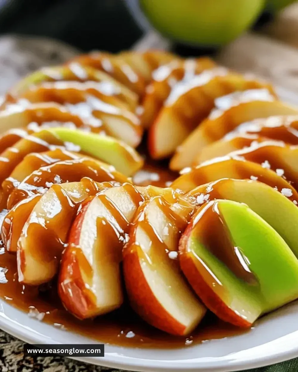 Delicious caramel apple slices drizzled with rich caramel sauce on a wooden board.