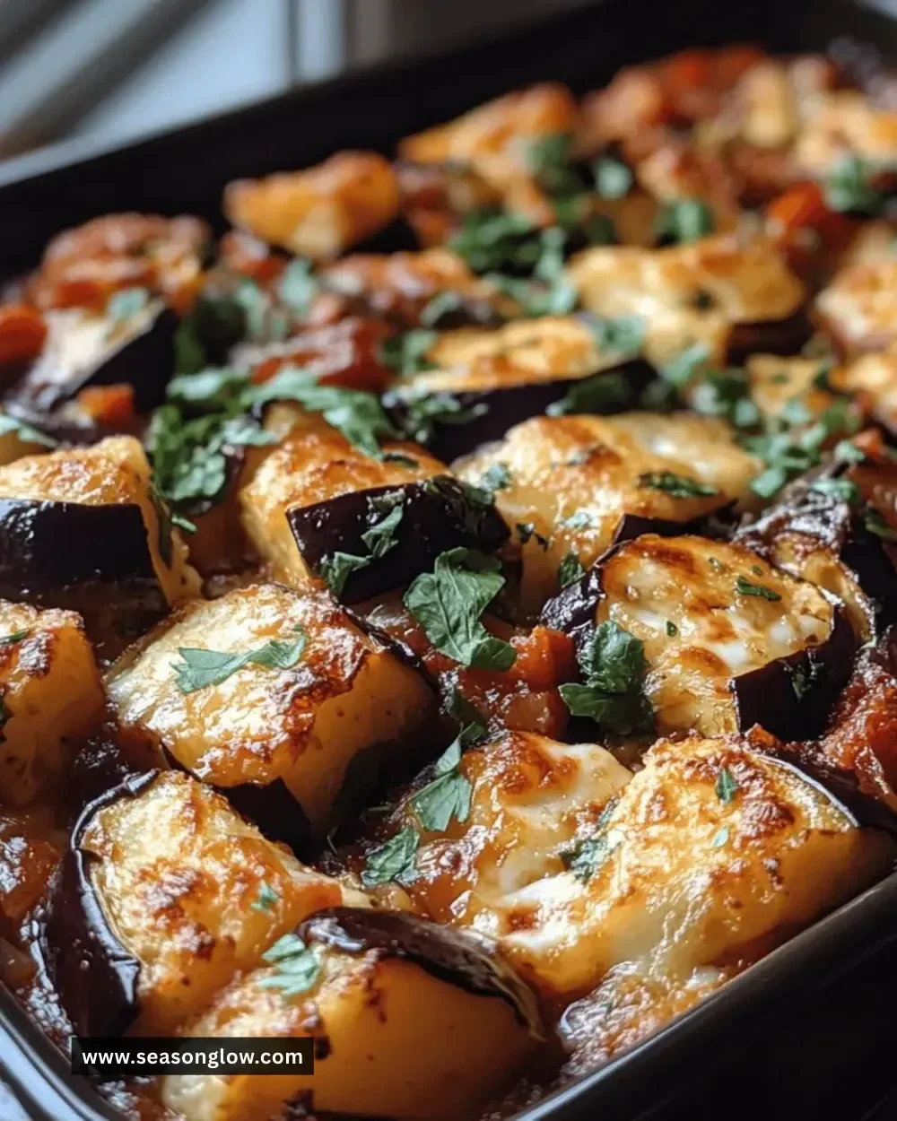 Irresistible eggplant and halloumi bake ready to serve in a casserole dish.