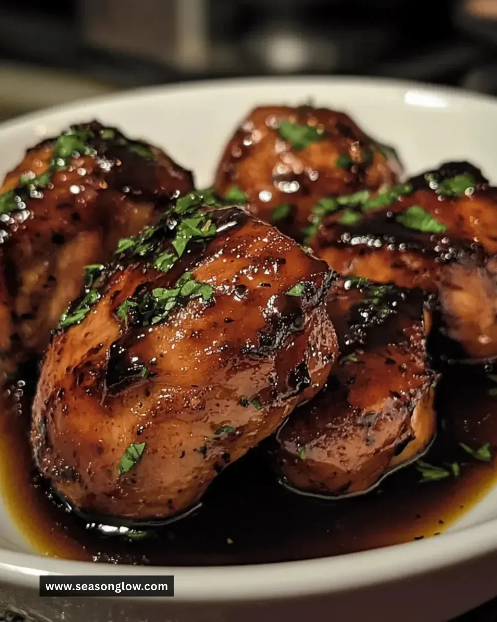 Delicious balsamic glazed chicken thighs served on a plate.