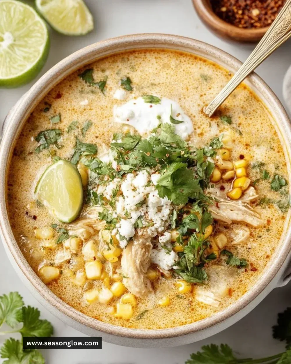 Bowl of creamy Mexican street corn soup topped with cilantro and lime.