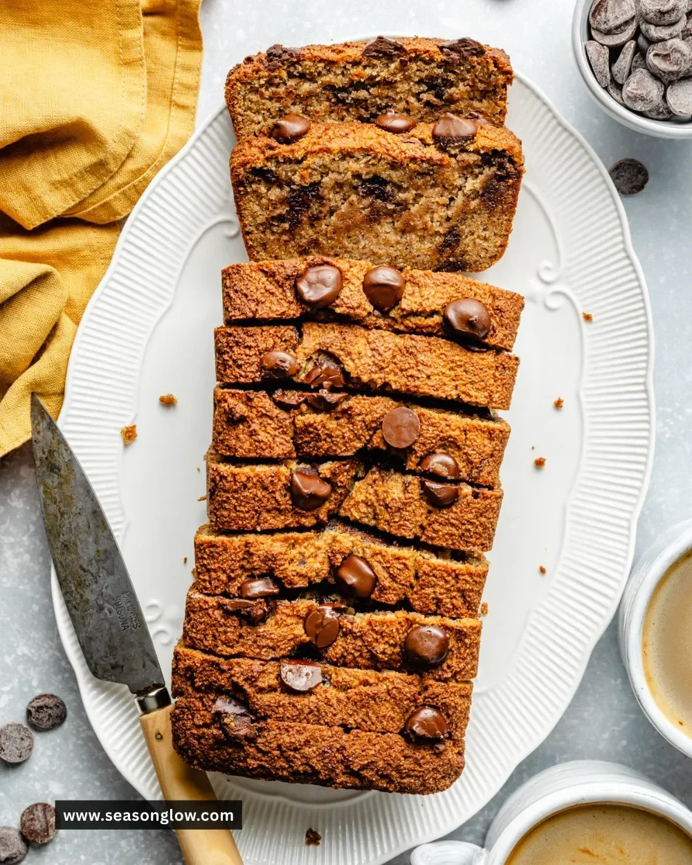 Freshly baked almond flour banana bread with slices on a wooden board.