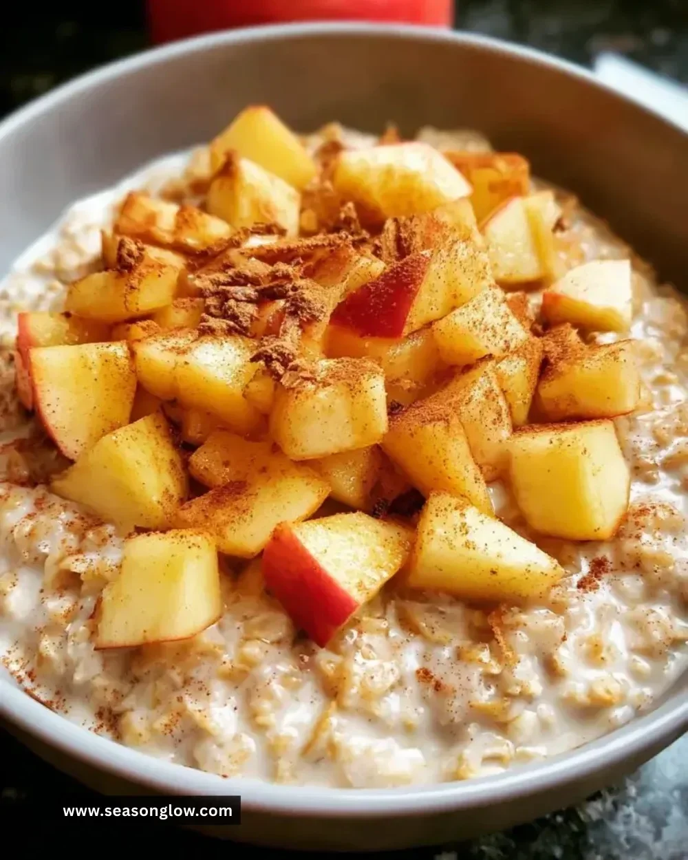 Bowl of warm Apple Cinnamon Oatmeal topped with fresh apples and cinnamon