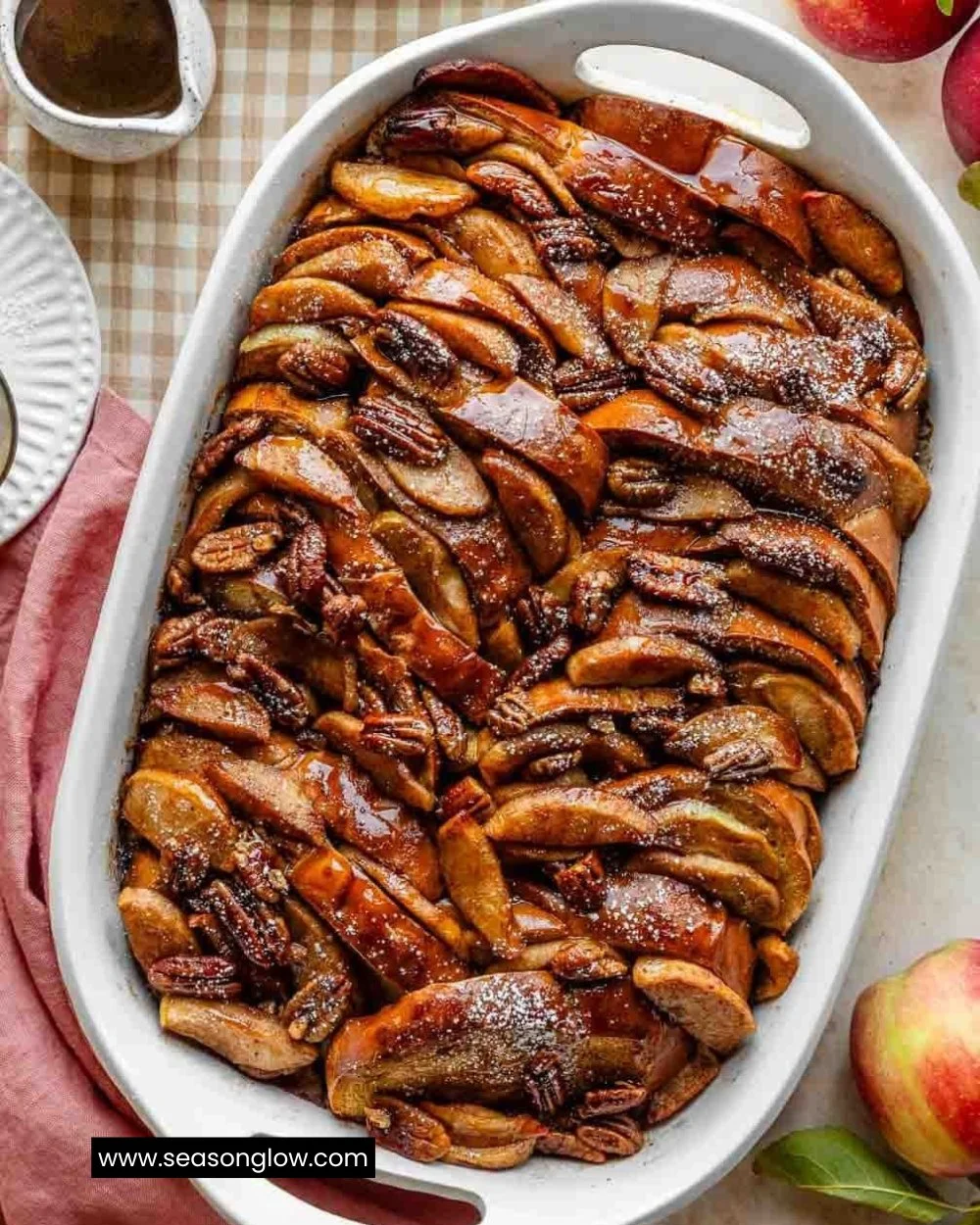 Baked apple cider French toast served with syrup and apples on a plate