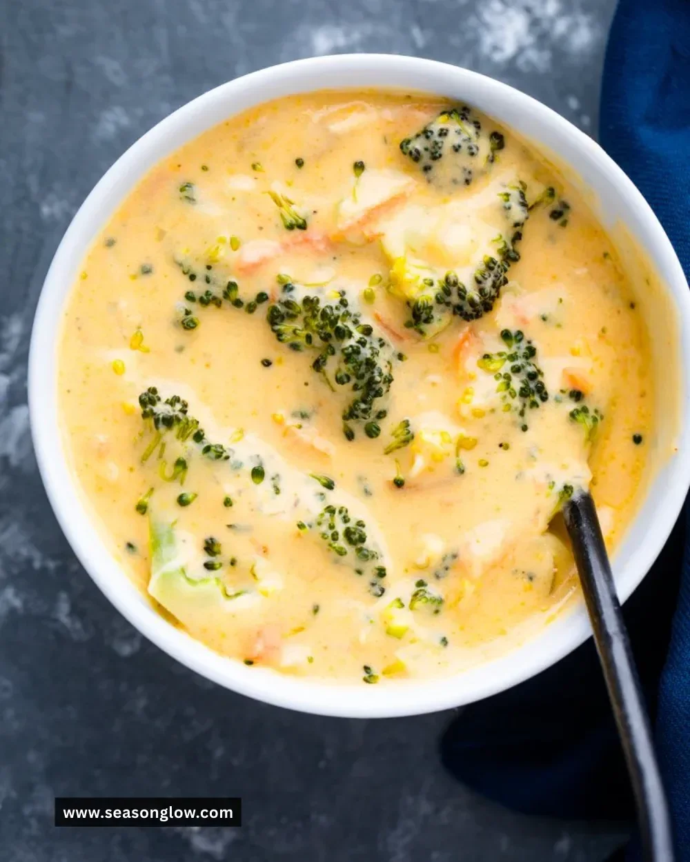 Bowl of creamy broccoli cheddar soup topped with fresh broccoli florets