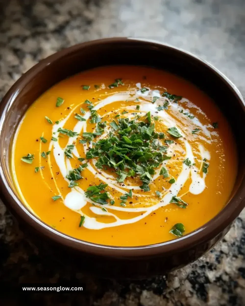 Bowl of creamy butternut squash soup topped with herbs