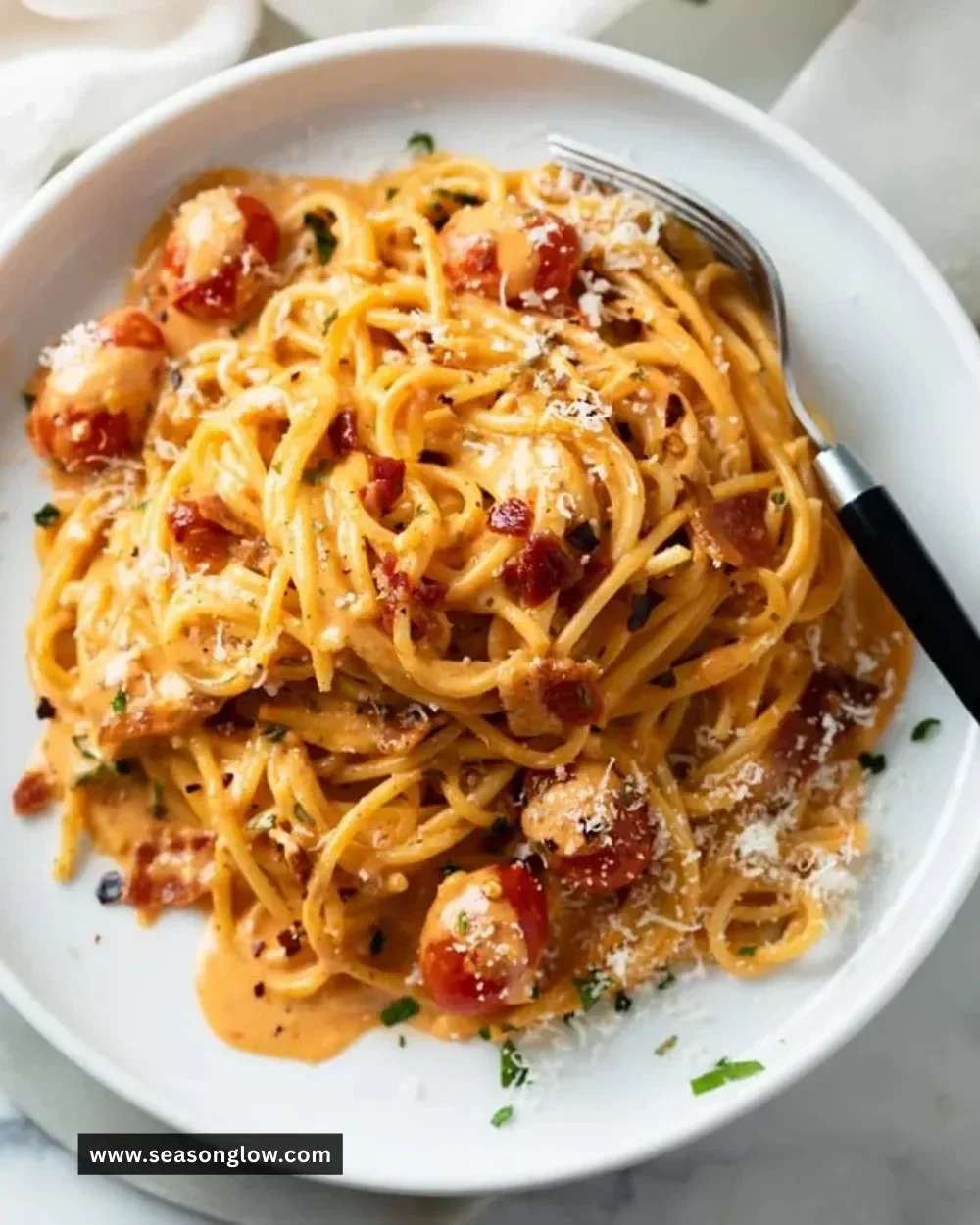 Creamy bacon pasta dish served in a bowl, garnished with herbs.