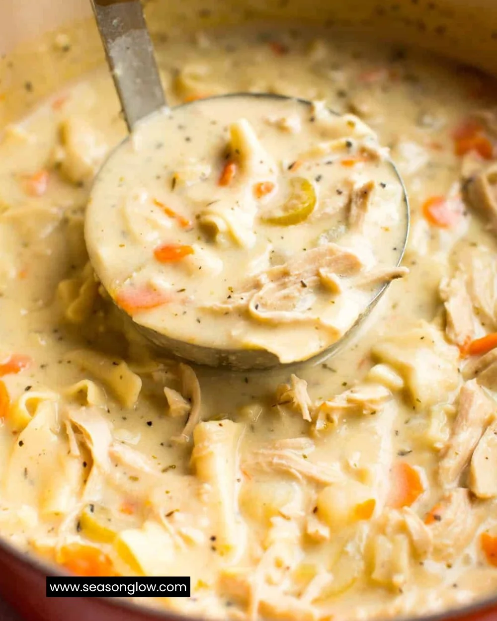 Bowl of creamy chicken noodle soup garnished with parsley
