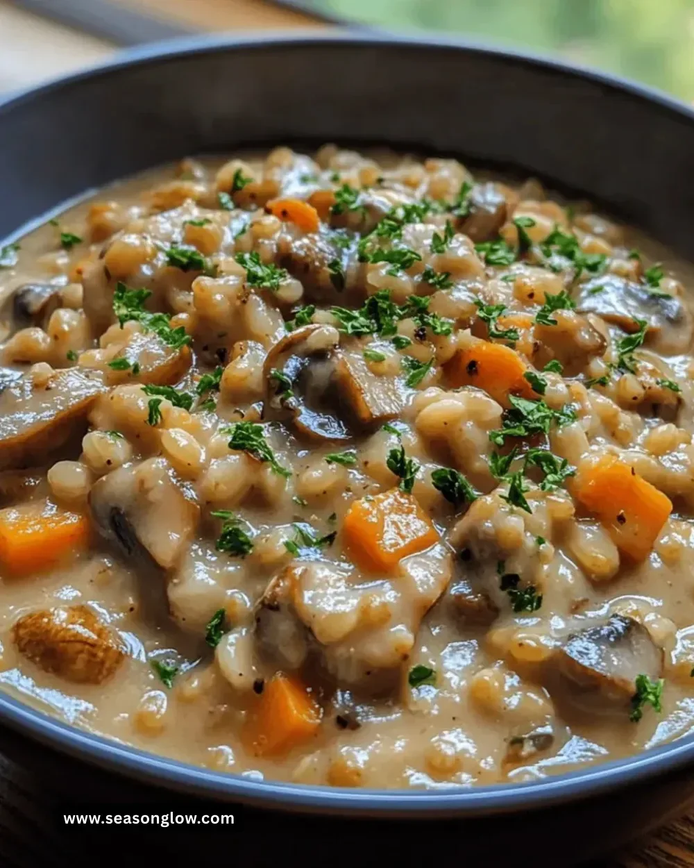 Bowl of creamy mushroom barley stew garnished with fresh herbs