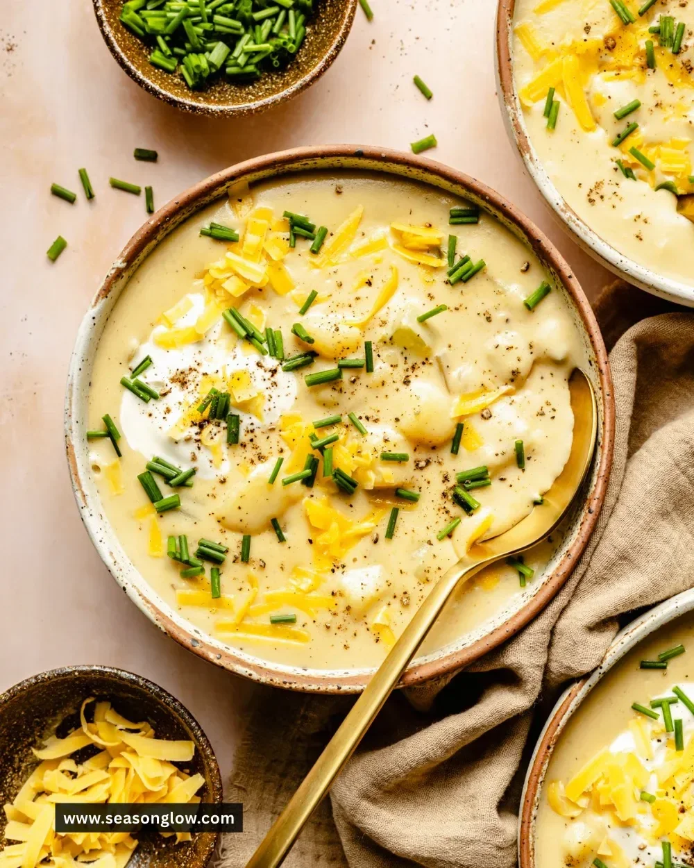Bowl of creamy potato soup garnished with herbs and served with bread