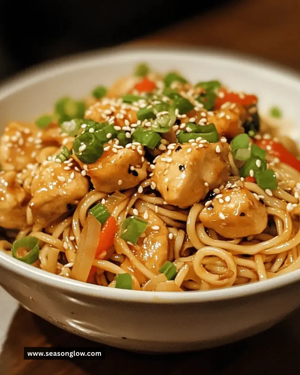 Plate of easy Asian sesame chicken noodles with vegetables and sesame seeds