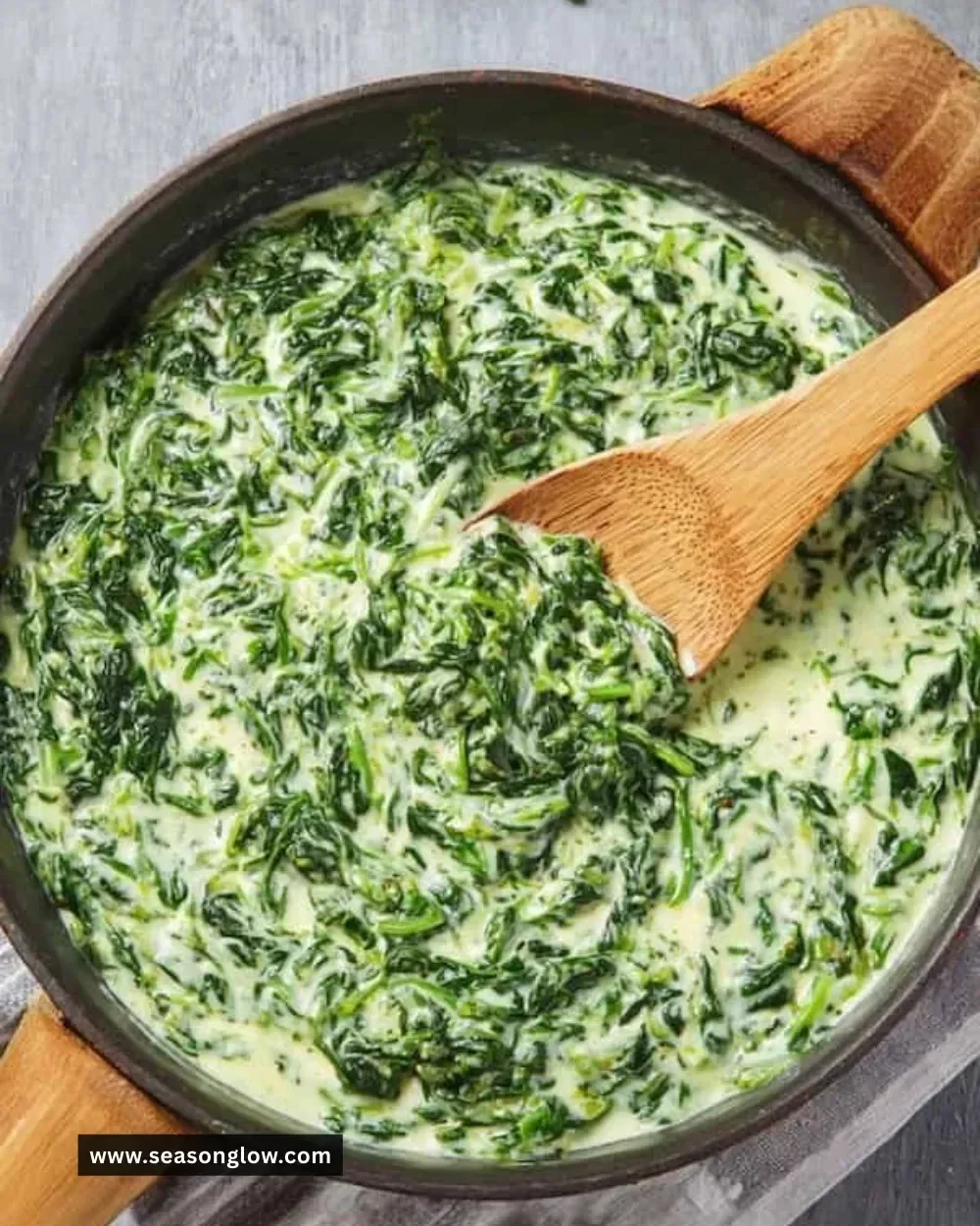 Plate of easy creamed spinach ready to serve, garnished with herbs.