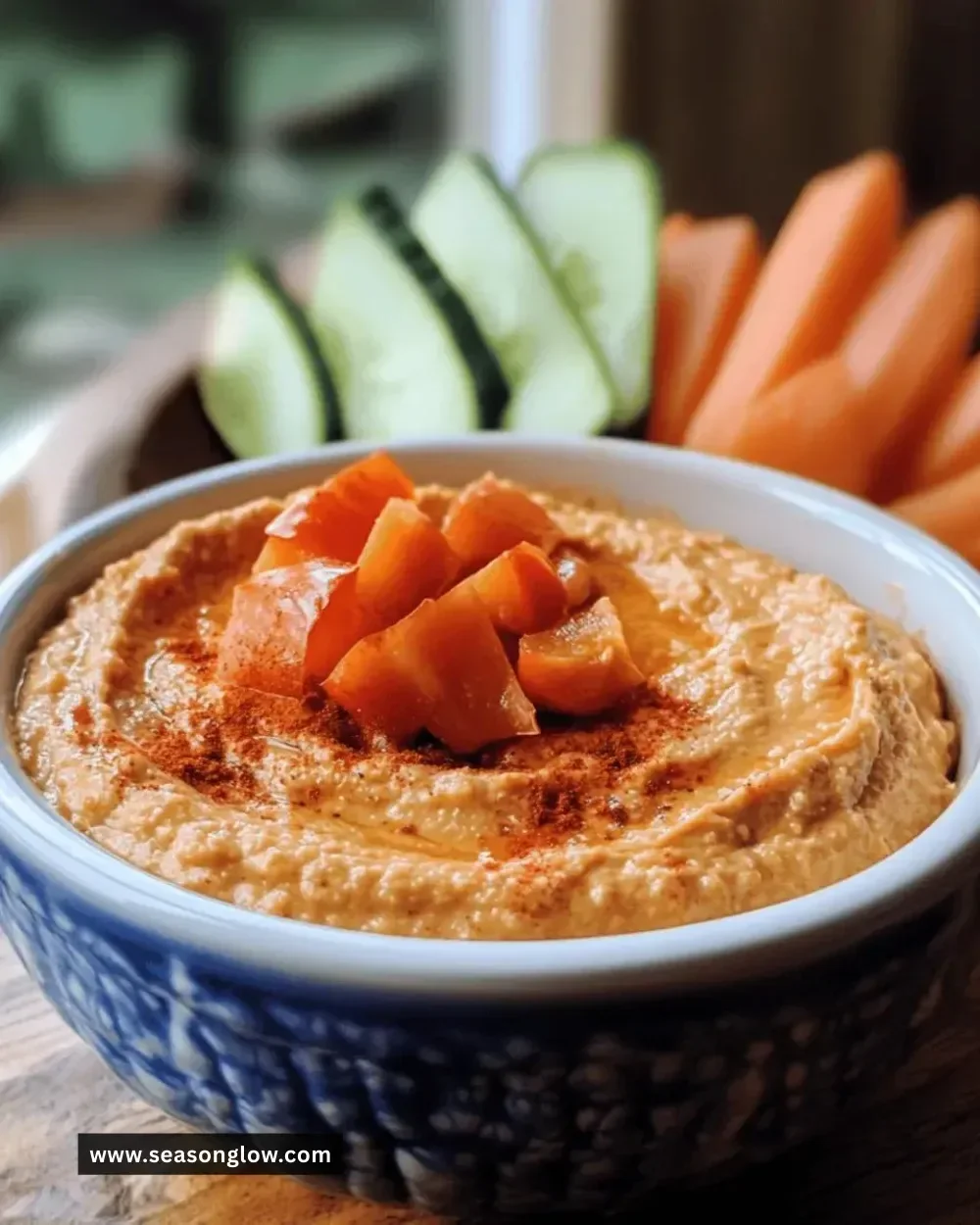 Bowl of creamy roasted red pepper hummus with fresh vegetables for dipping