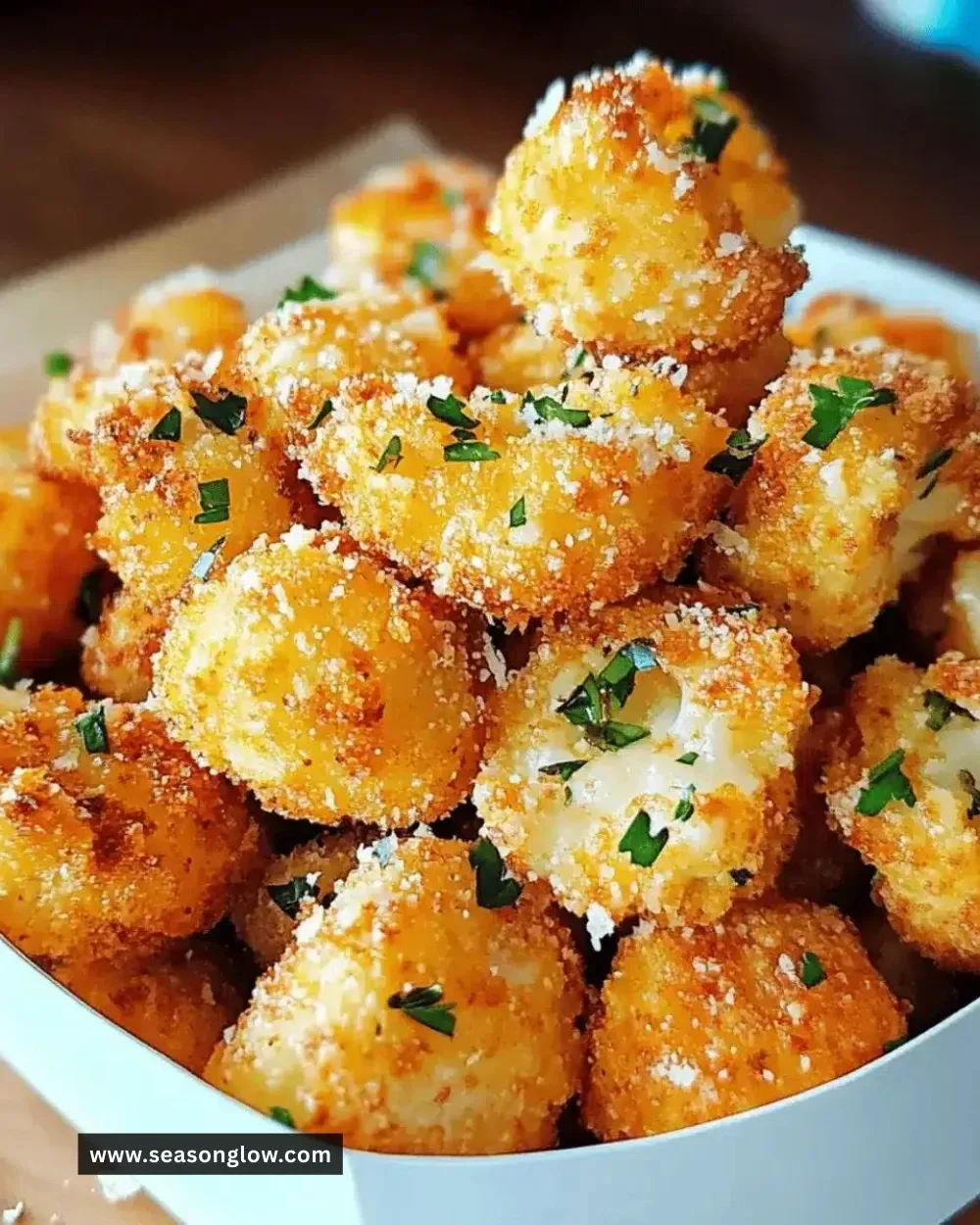 Crispy parmesan cauliflower bites on a plate, ready to eat.