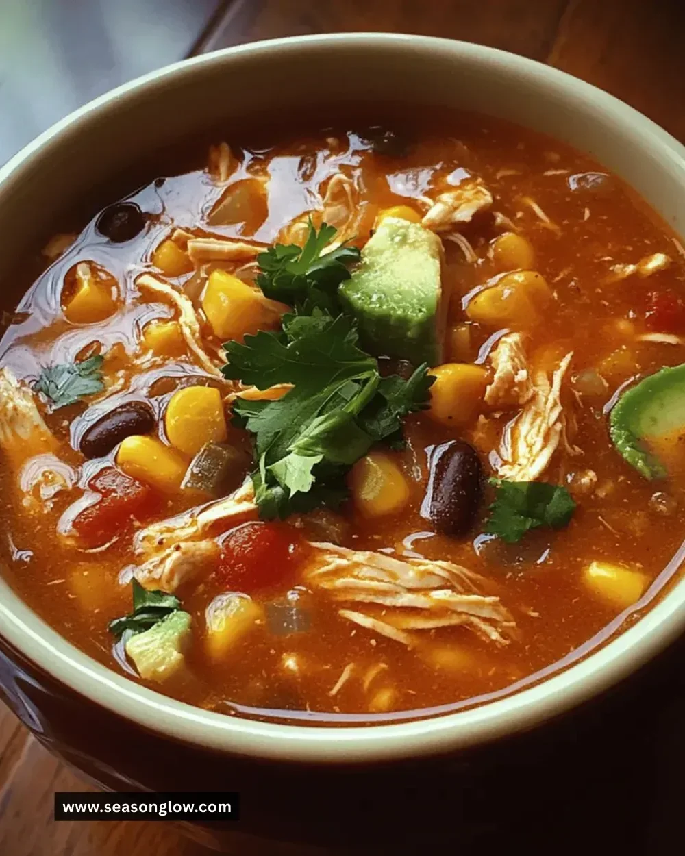 Bowl of easy Crockpot chicken tortilla soup topped with tortilla strips and cilantro