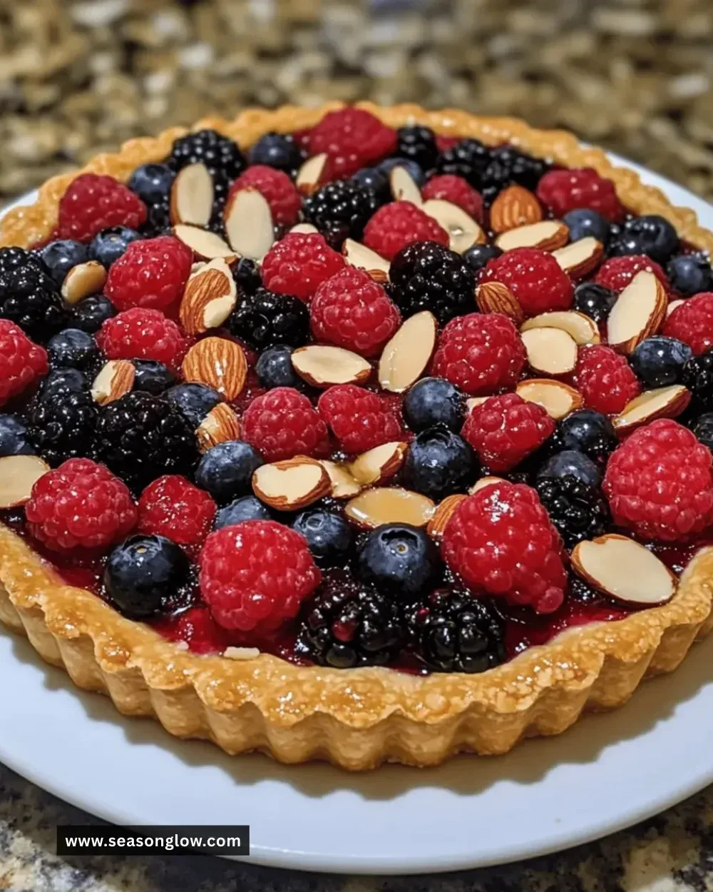 Sliced gluten-free almond berry tart with fresh berries on top