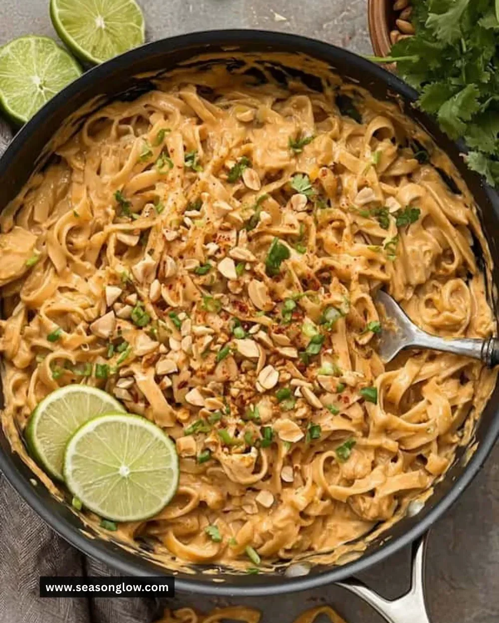 Bowl of easy peanut noodles garnished with green onions and peanuts.