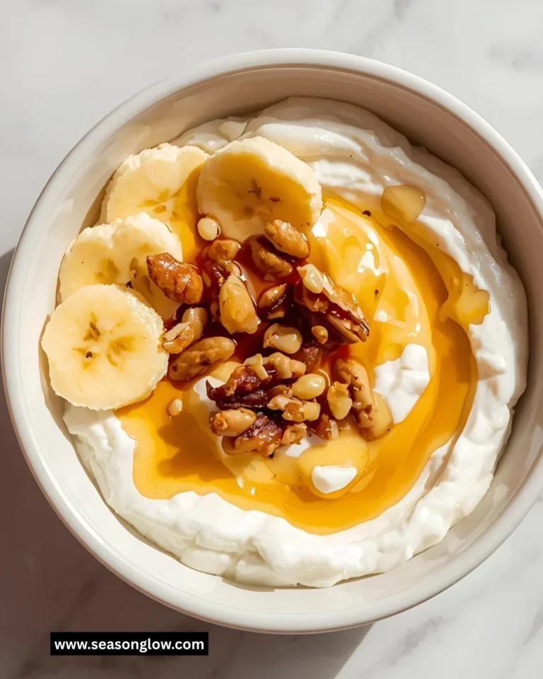 A bowl of Greek yogurt drizzled with honey and topped with fresh fruits.