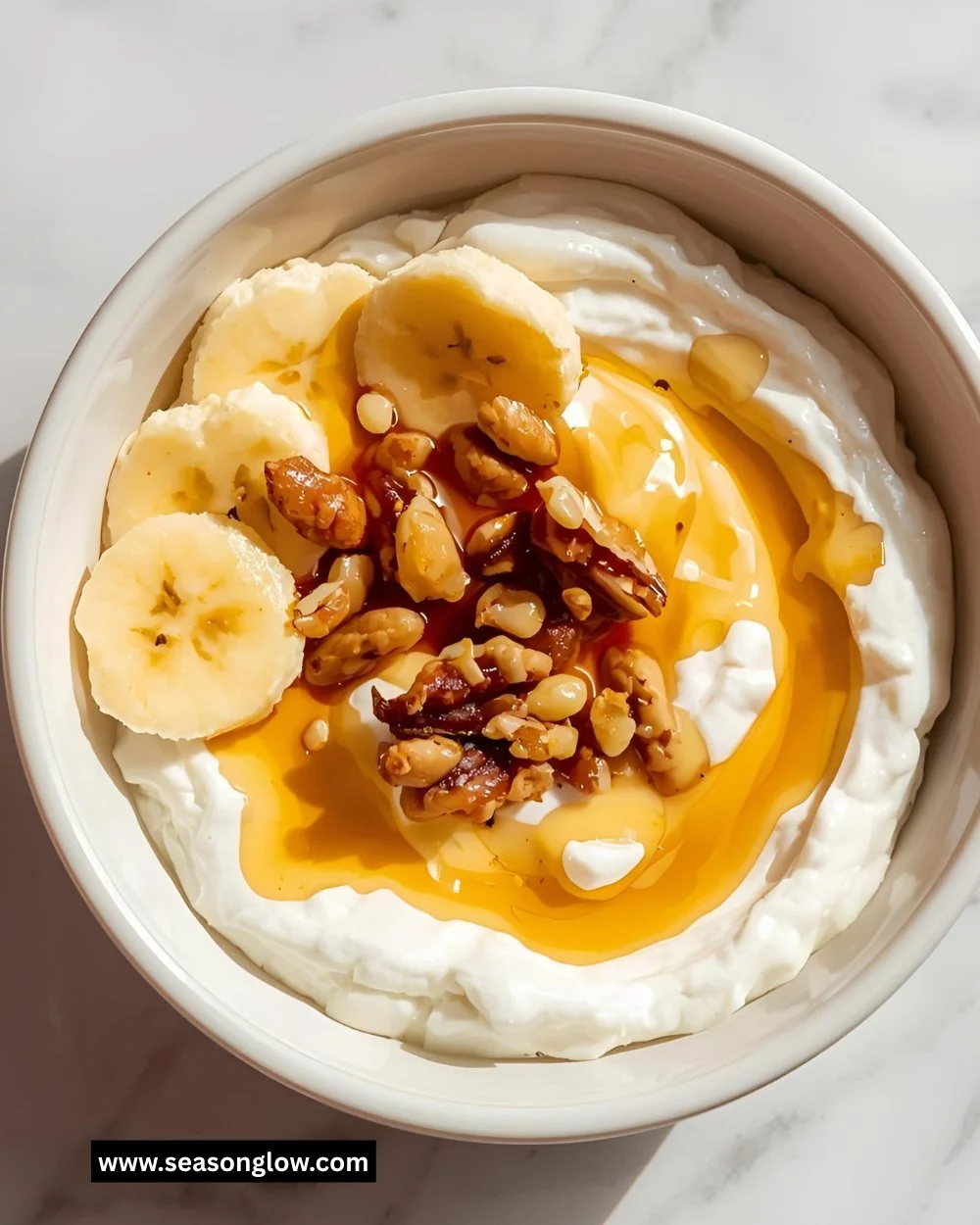 A bowl of Greek yogurt drizzled with honey and topped with fresh fruits.