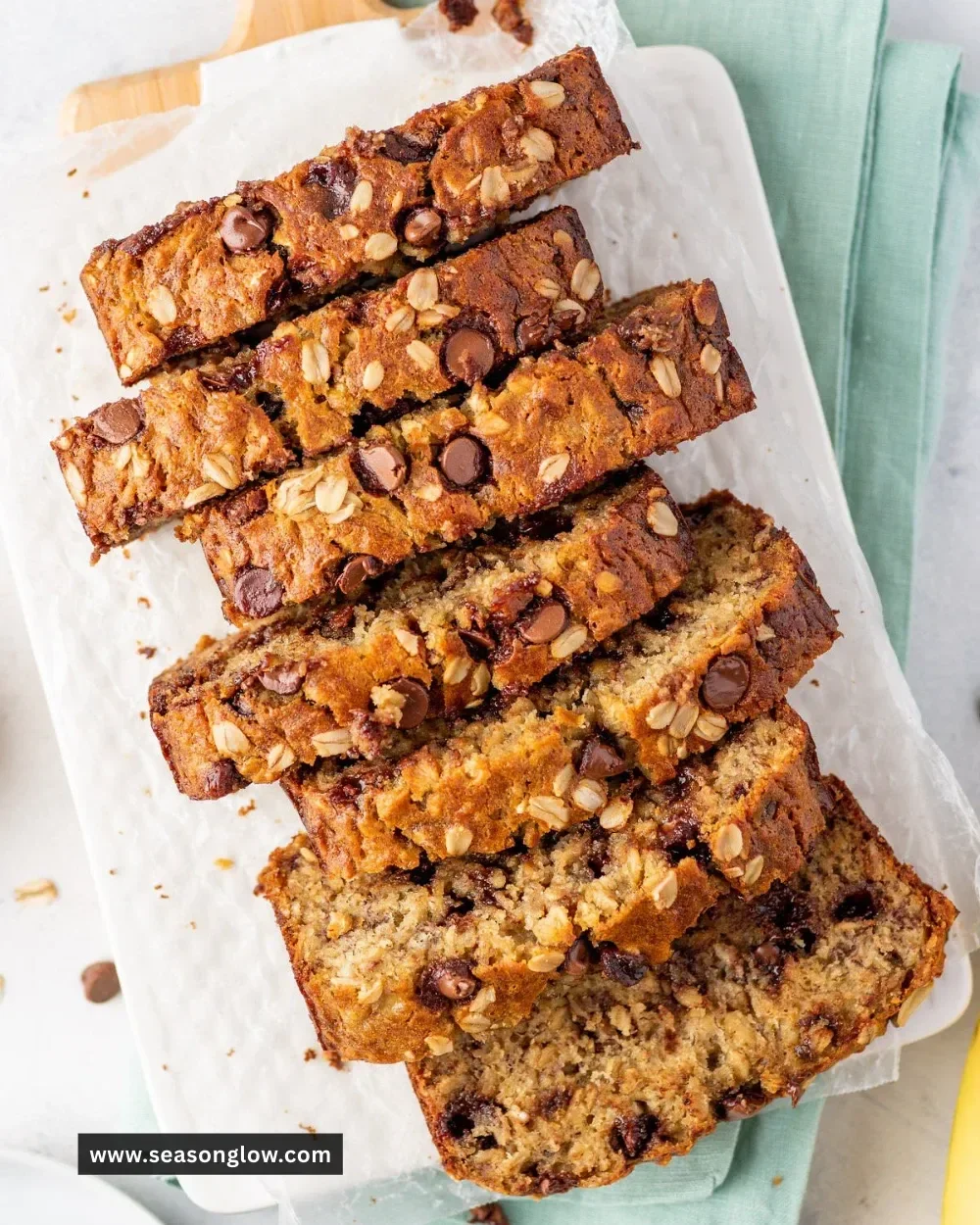 Healthy oatmeal banana bread loaf sliced on a wooden cutting board