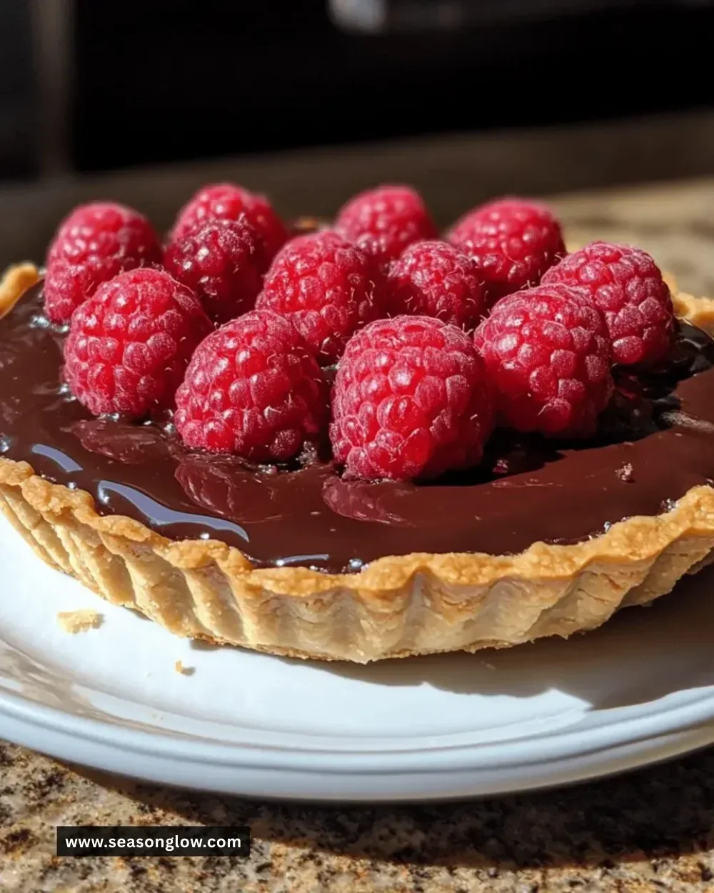 Irresistible chocolate raspberry tart with fresh raspberries and chocolate glaze.