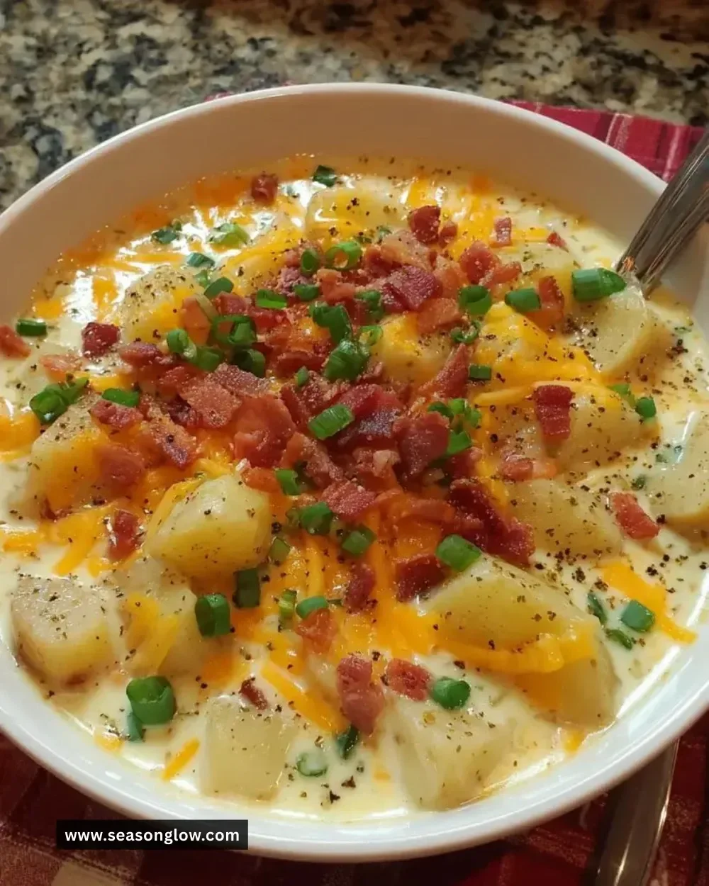Bowl of loaded potato cheese soup topped with green onions and cheese