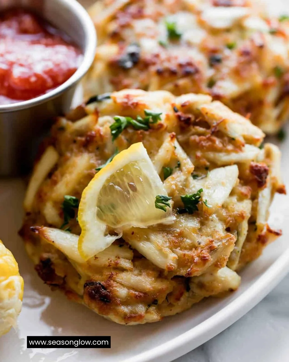 Plate of Maryland crab cakes garnished with herbs and lemon