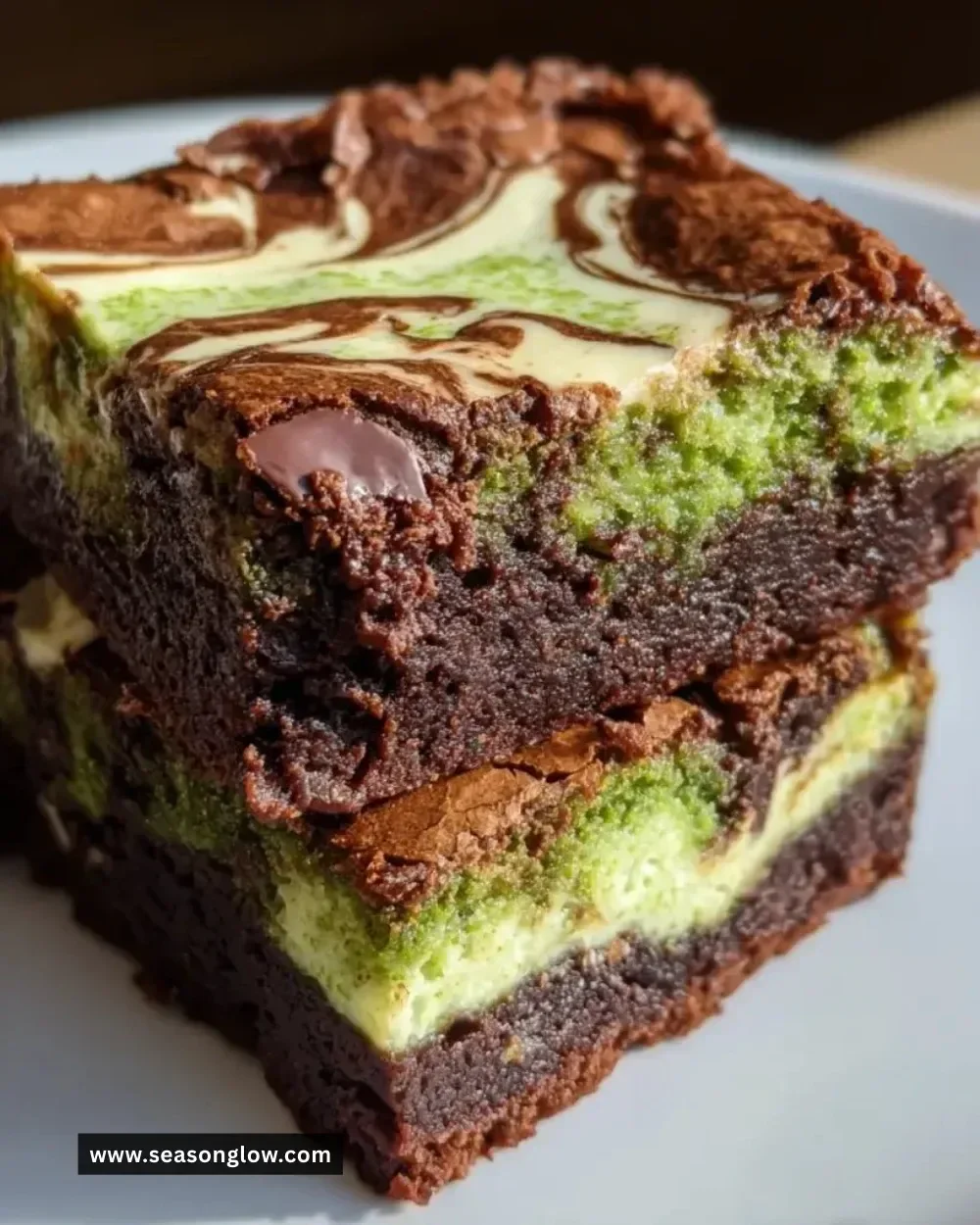 Matcha cheesecake swirl brownies displayed on a rustic plate