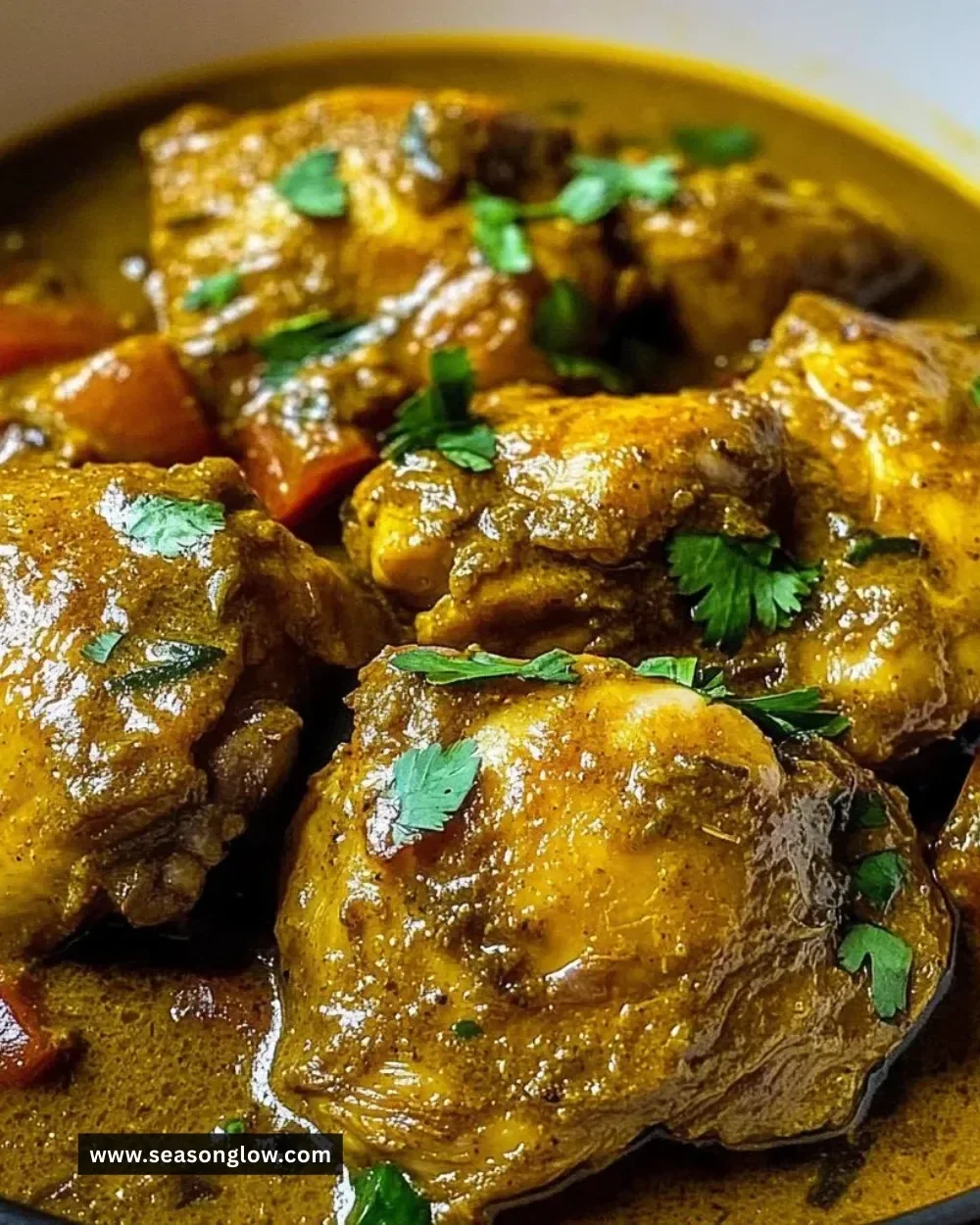 A delicious plate of One-Pot Jamaican Curry Chicken garnished with herbs.