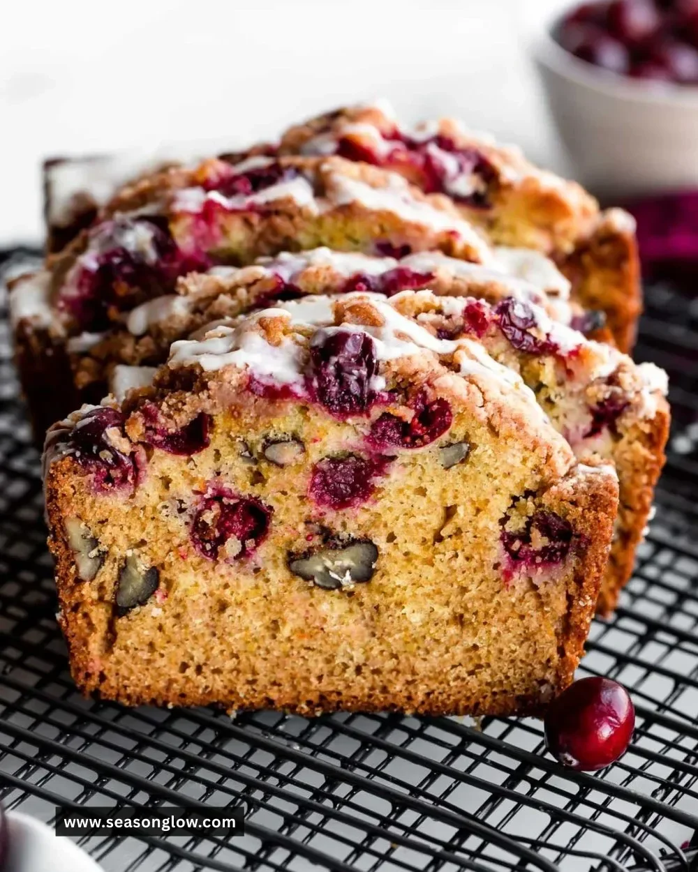 Sliced orange glazed cranberry bread topped with a shiny glaze