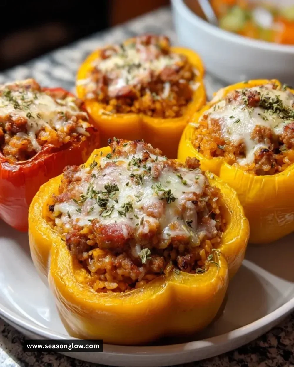 Pumpkin and sausage stuffed peppers on a plate, garnished with herbs.