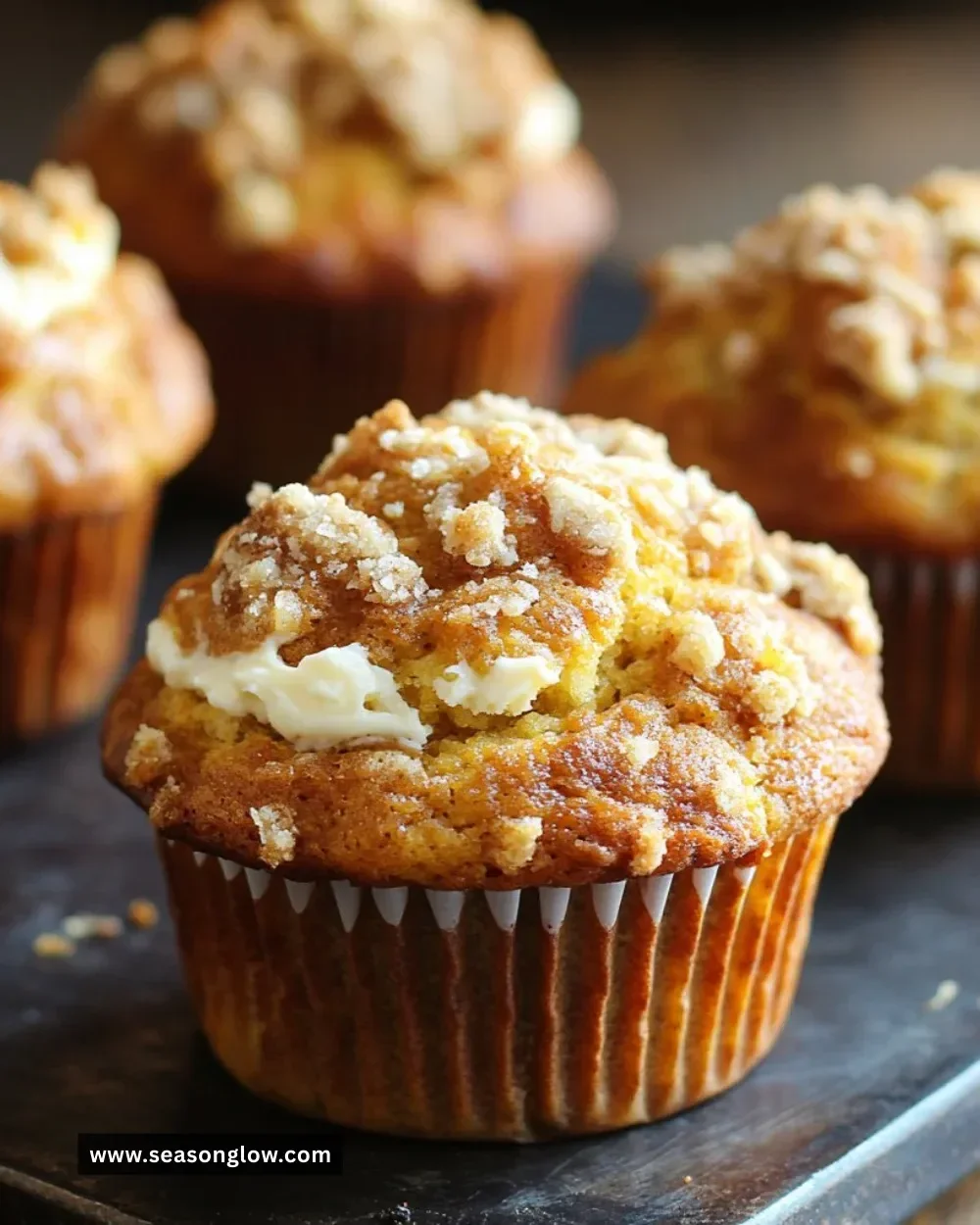 Freshly baked Pumpkin Cream Cheese Muffins with cream cheese filling.