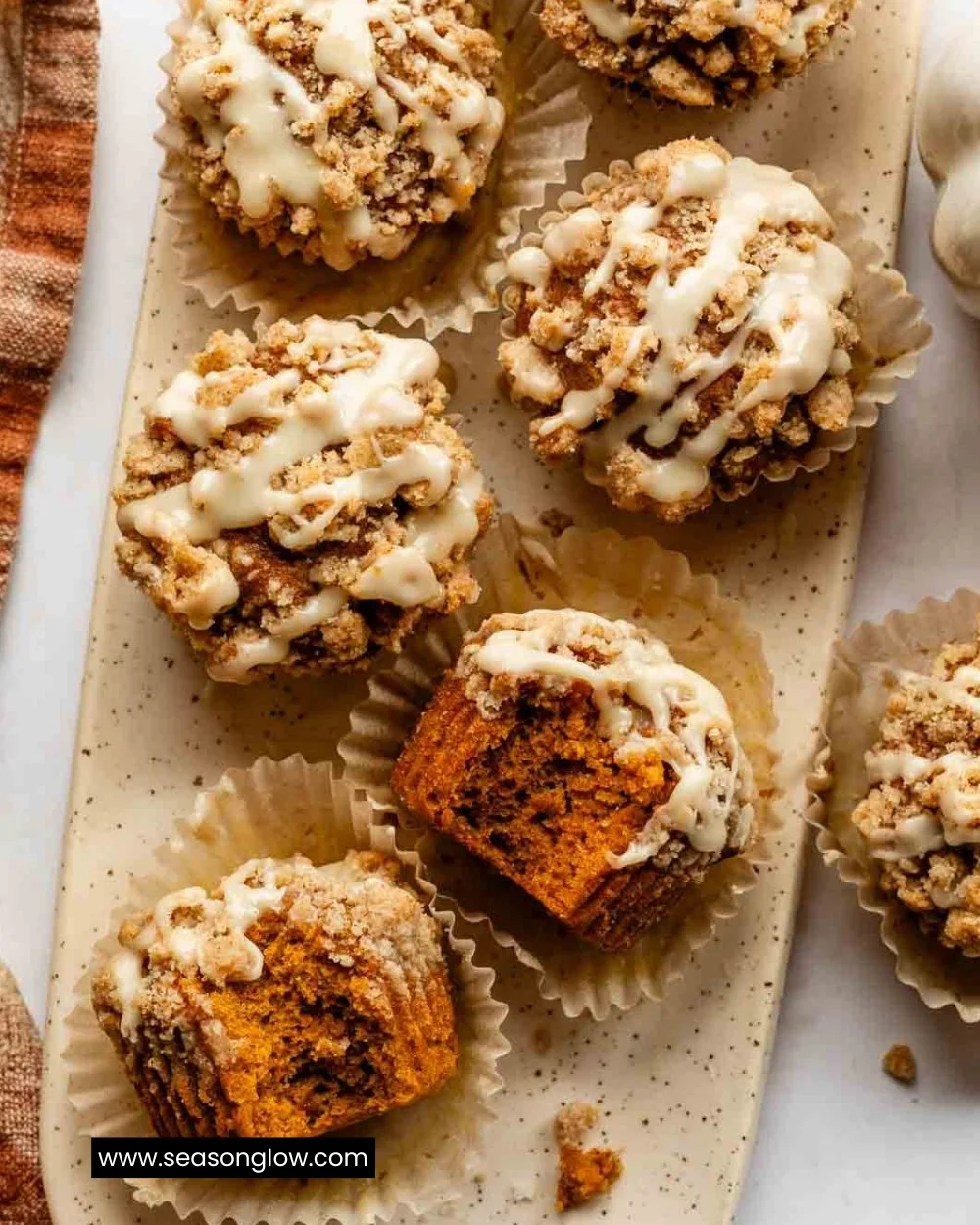 Delicious Pumpkin Crumb Cake Muffins with a crumble topping on a rustic table