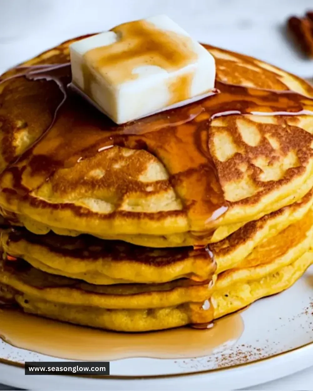 Golden brown pumpkin pancakes stacked with a drizzle of maple syrup
