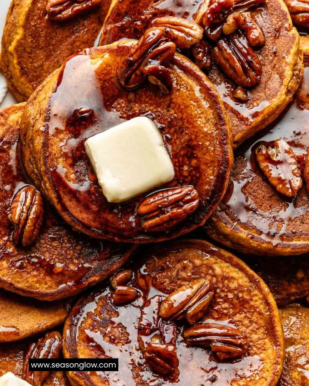Fluffy pumpkin pancakes topped with maple syrup and pumpkin seeds