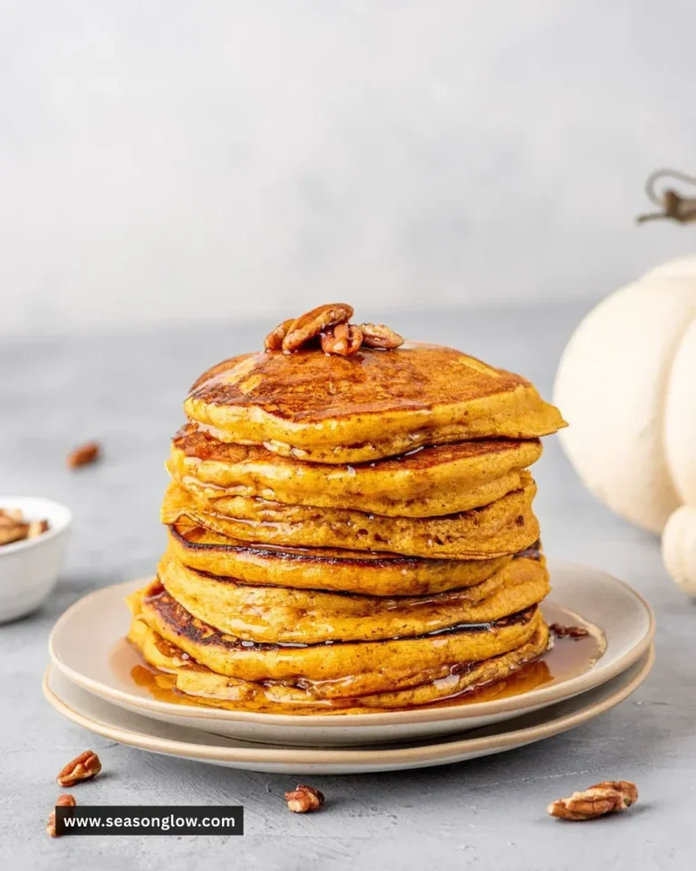 Delicious pumpkin spice pancakes served with maple syrup and whipped cream