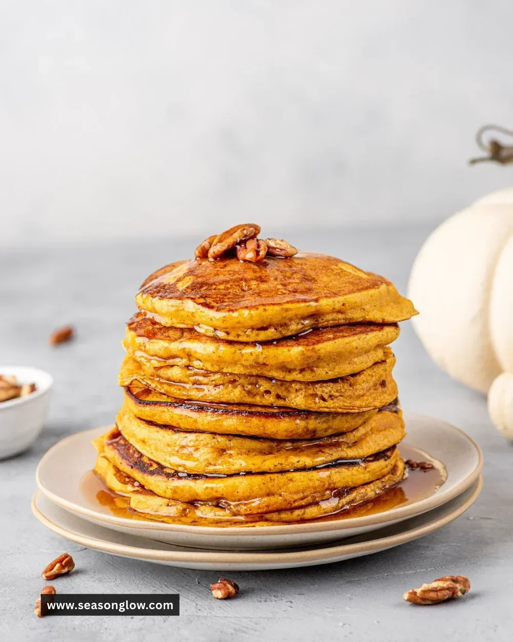 Delicious pumpkin spice pancakes served with maple syrup and whipped cream