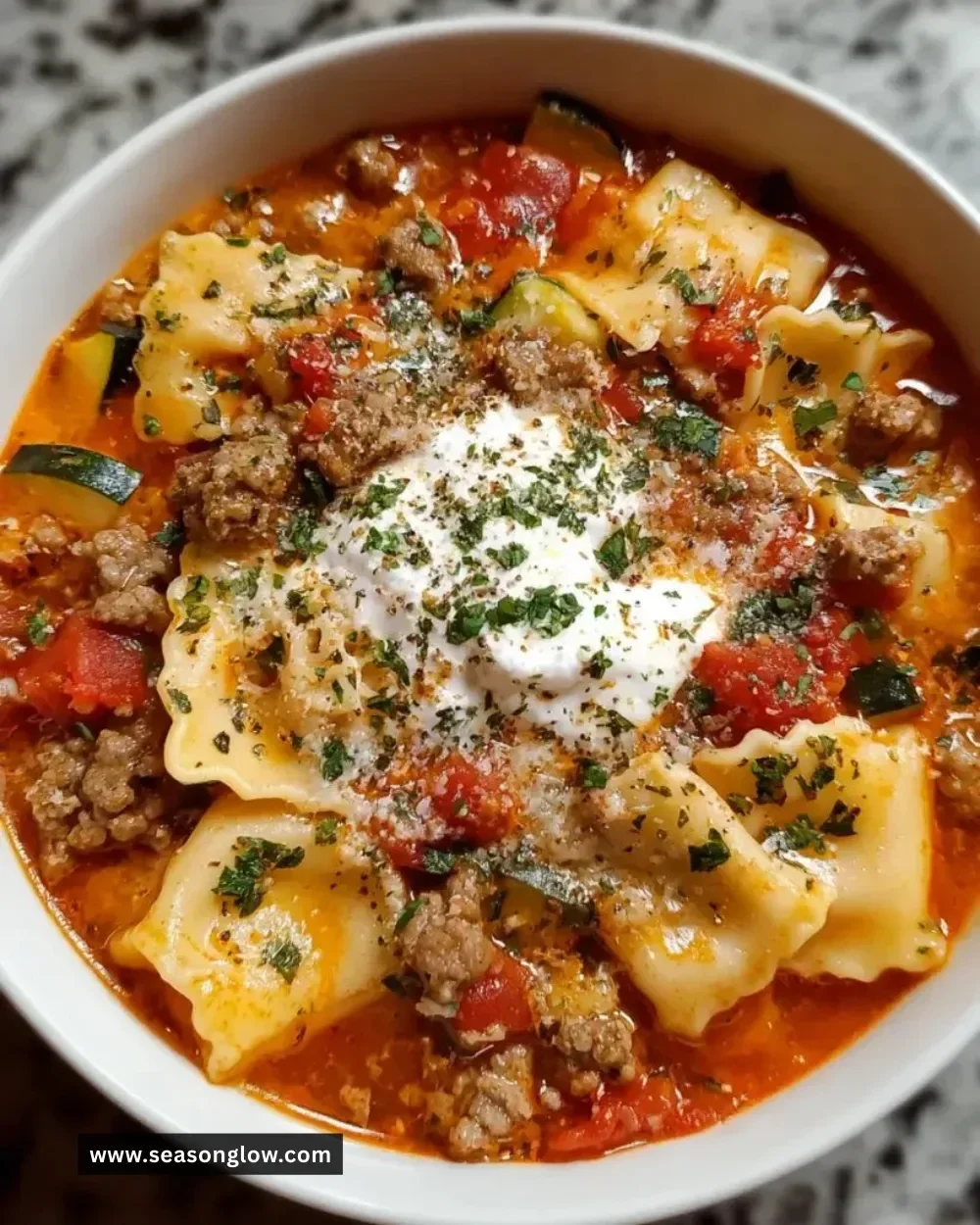Bowl of Sausage Lasagna Soup with melted cheese and herbs