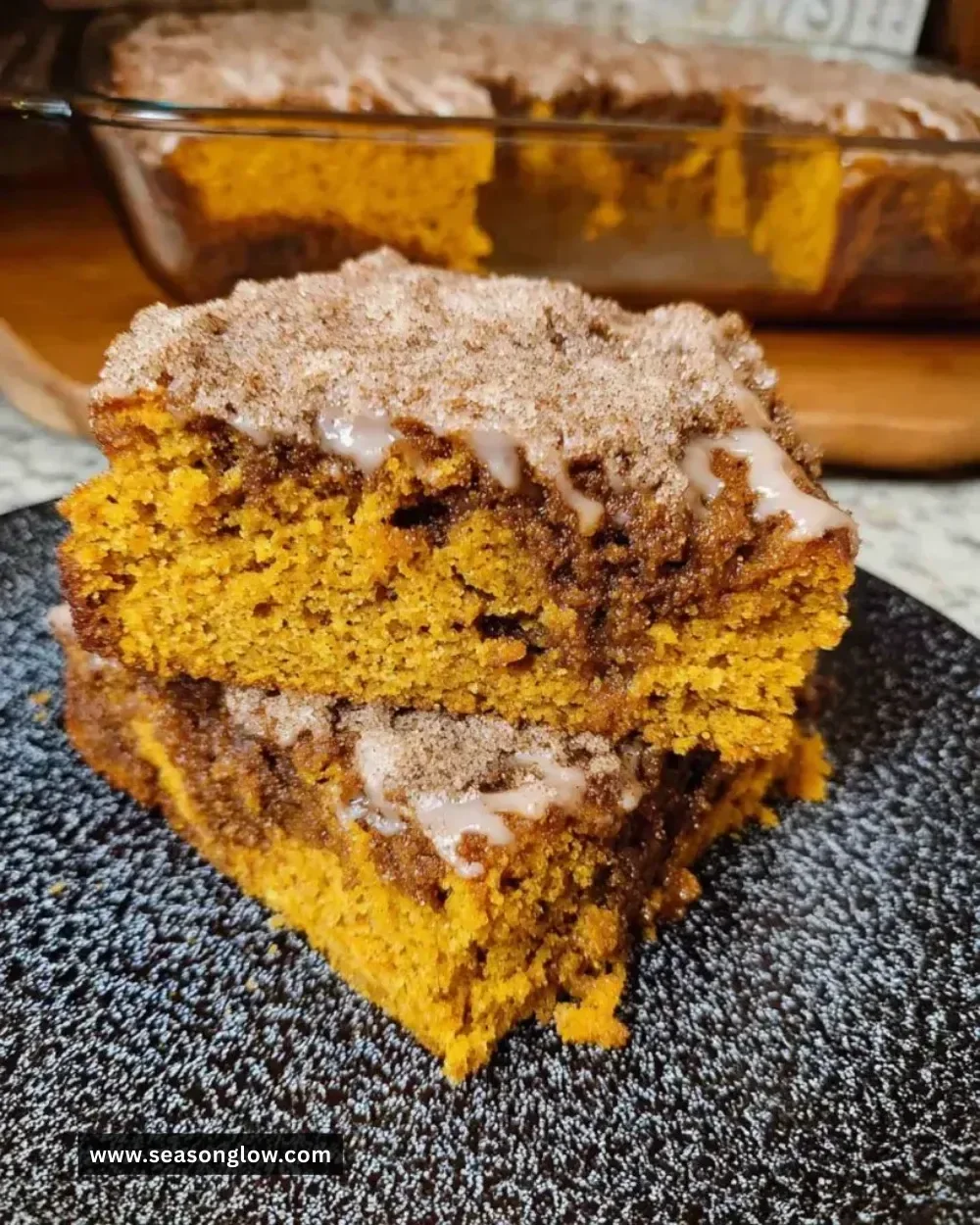 Sourdough pumpkin coffee cake topped with spices and nuts on a rustic table