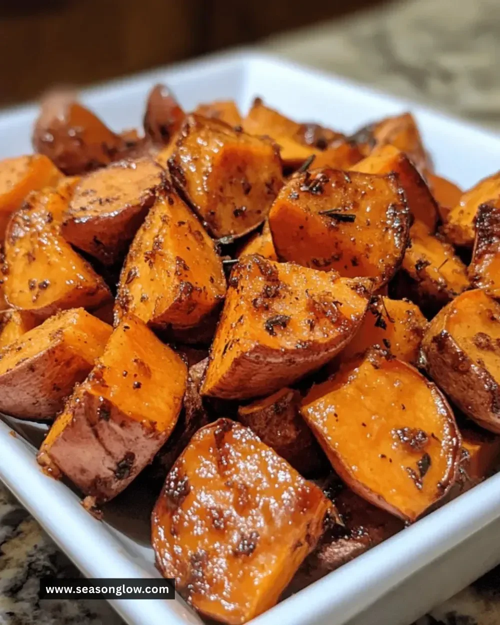 Bowl of brown sugar roasted sweet potatoes with crispy edges and caramelized glaze