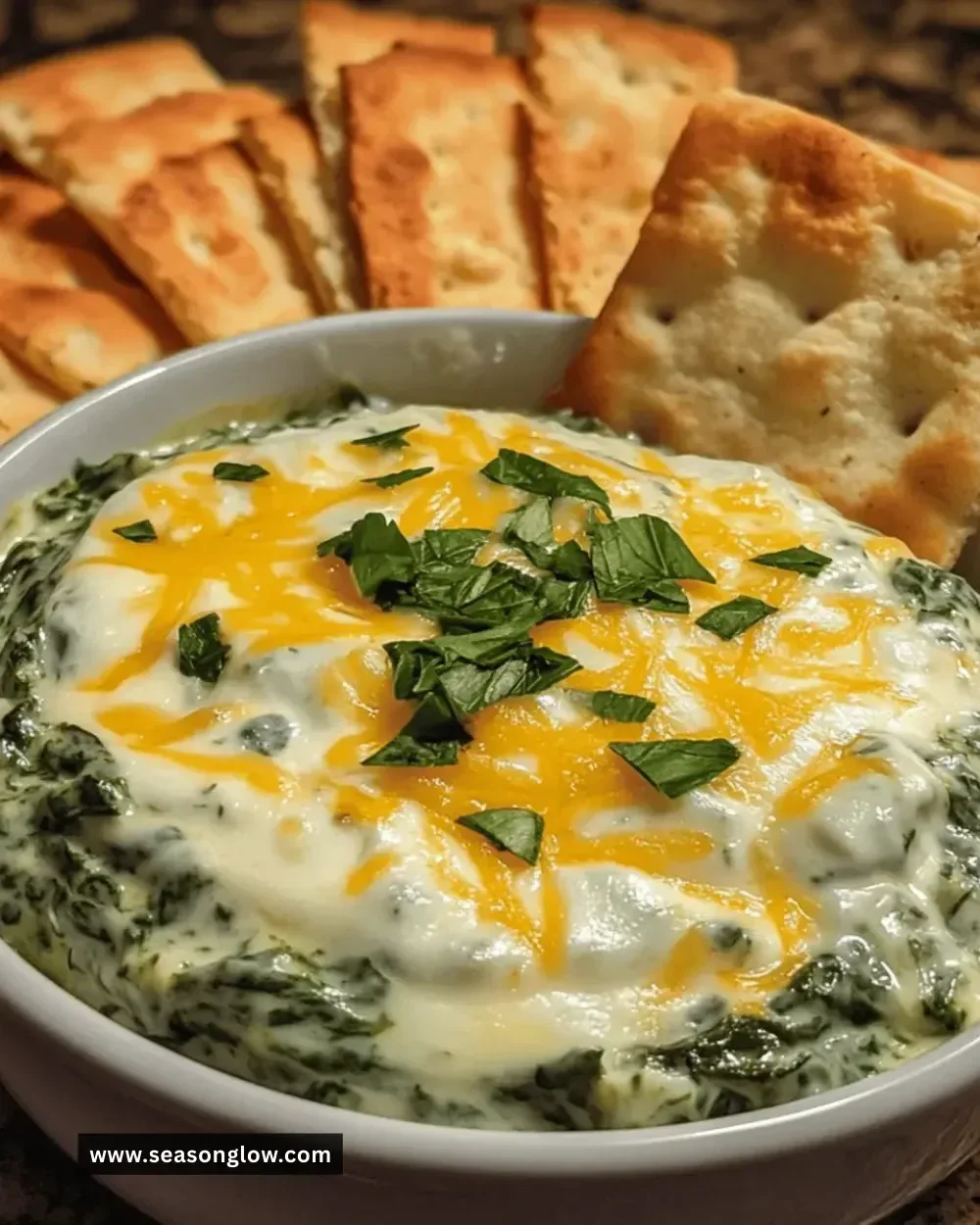 Creamy spinach cheese dip served in a bowl with tortilla chips