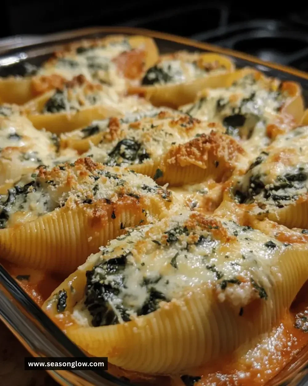 Plate of creamy spinach and ricotta stuffed shells garnished with herbs