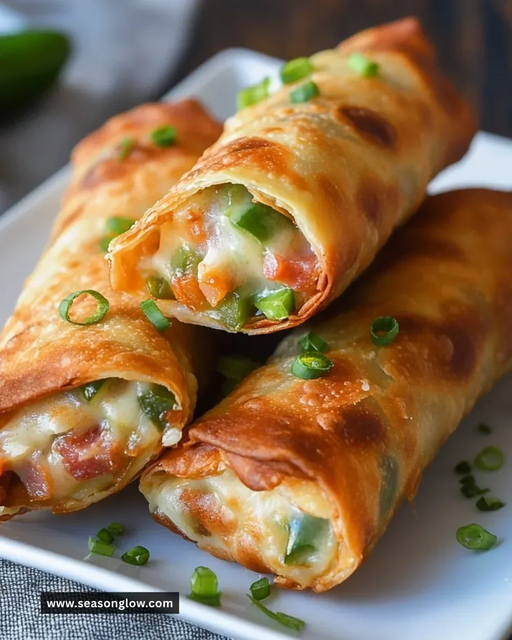 Turkey Bacon Jalapeño Popper Eggrolls on a plate garnished with dipping sauce