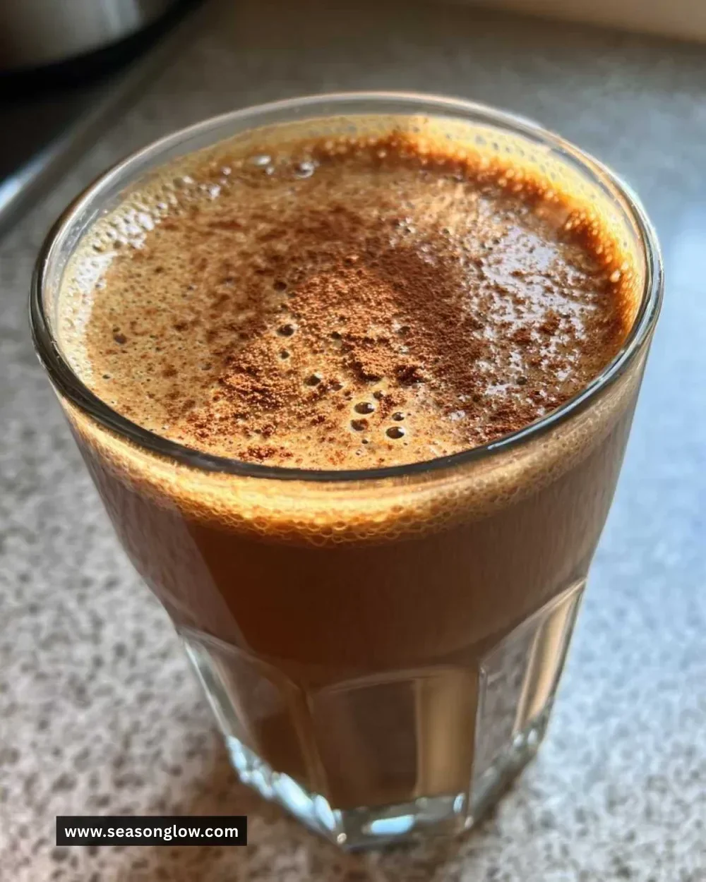 5-Minute gingerbread smoothie in a glass topped with cinnamon and whipped cream.
