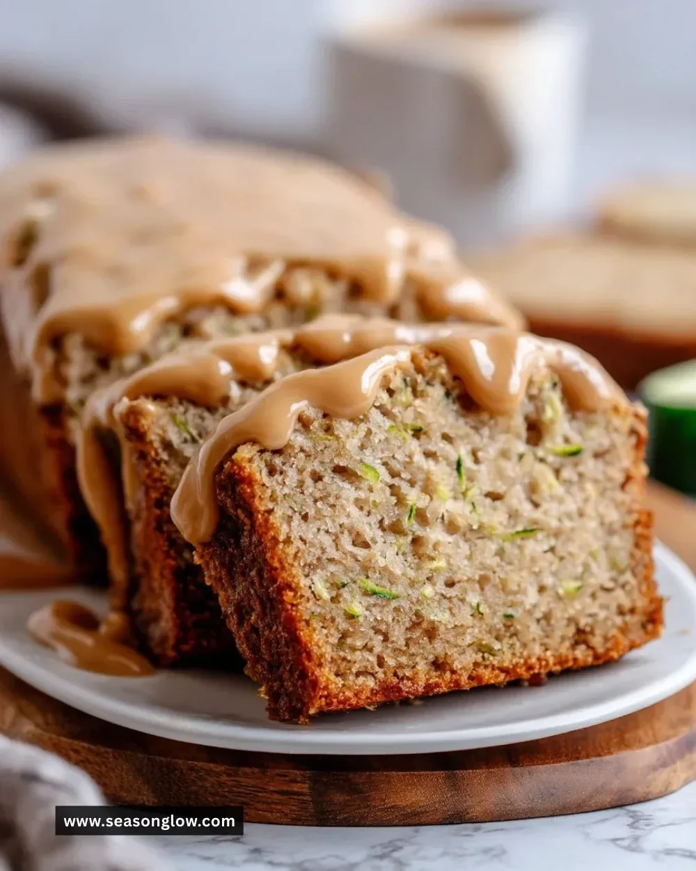 Slice of moist apple zucchini bread with brown sugar frosting on a plate