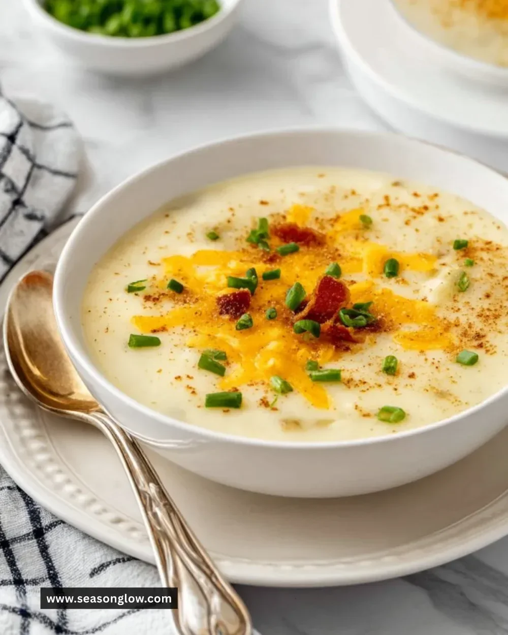 Bowl of warm and creamy Baked Potato Soup topped with chives and shredded cheese